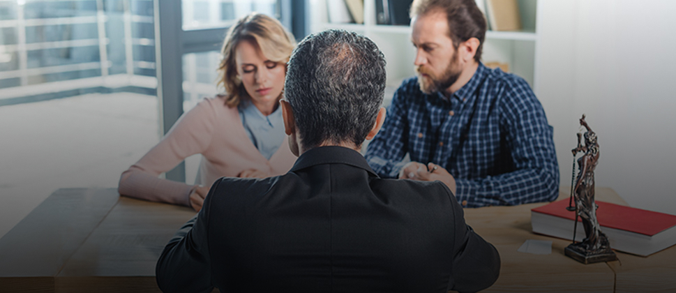 male and female couple sitting with a lawyer
